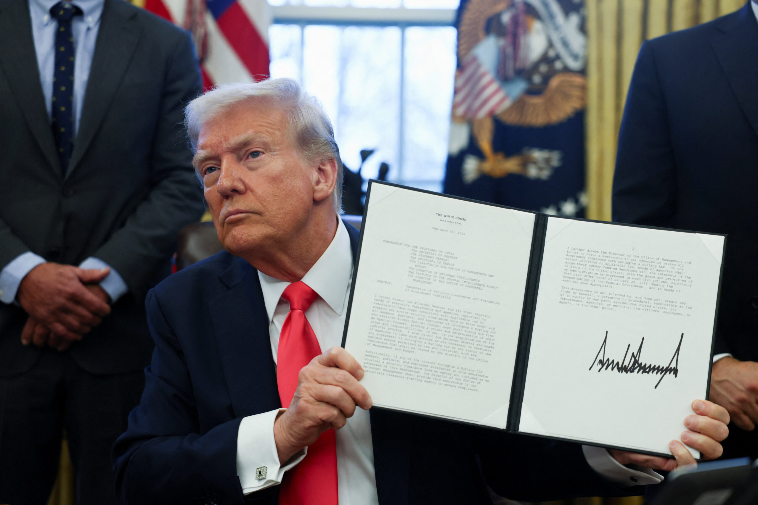 U.S. President Donald Trump signs an executive order in the Oval Office, at the White House in Washington